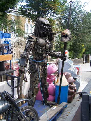 Illustration for article titled Steampunk Predator Stands Guard Over Junk Shop